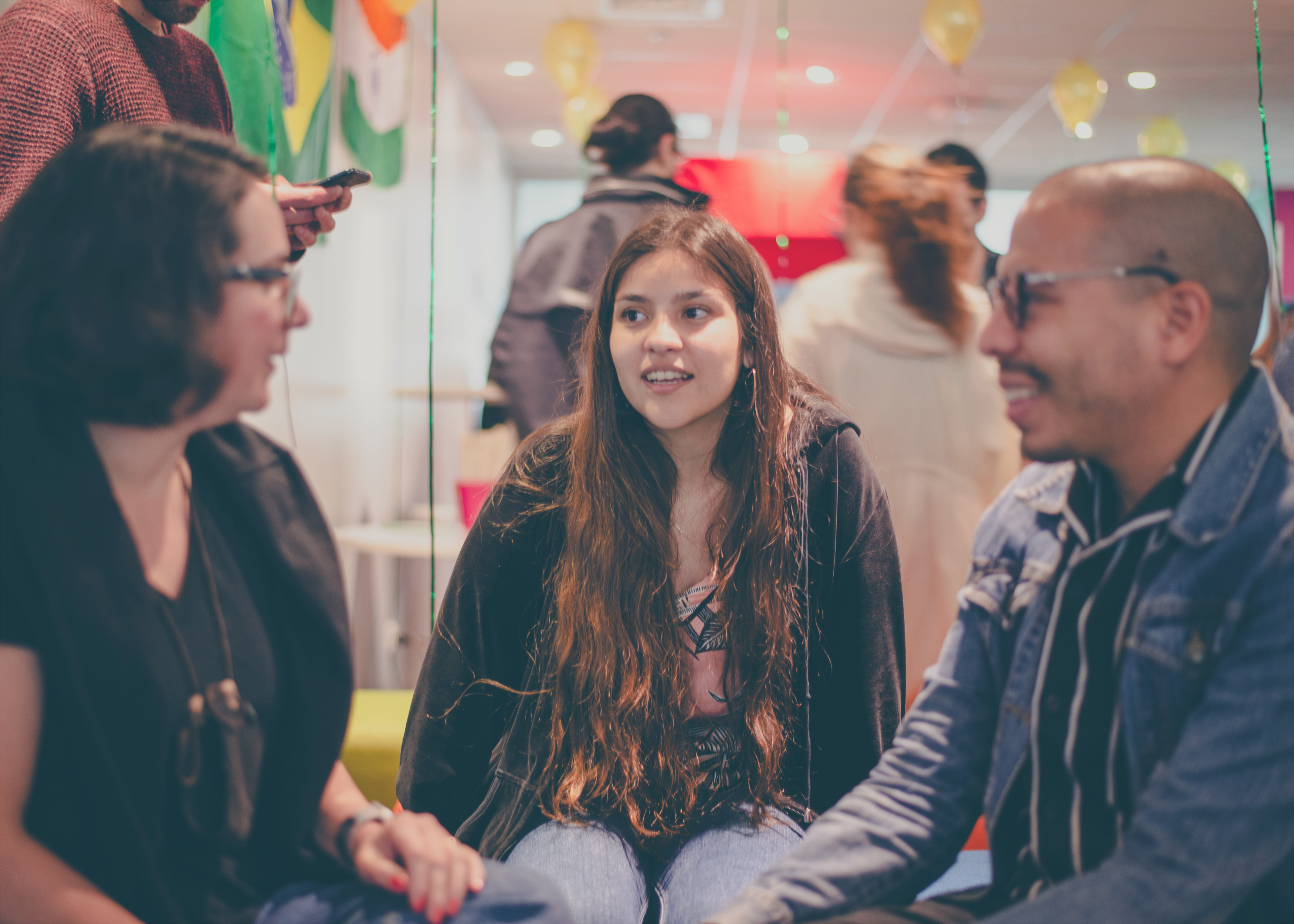 A group of three individuals engages in lively conversation in the office in Santiago, Chile.